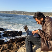 Ahnaf working on a laptop beside the water